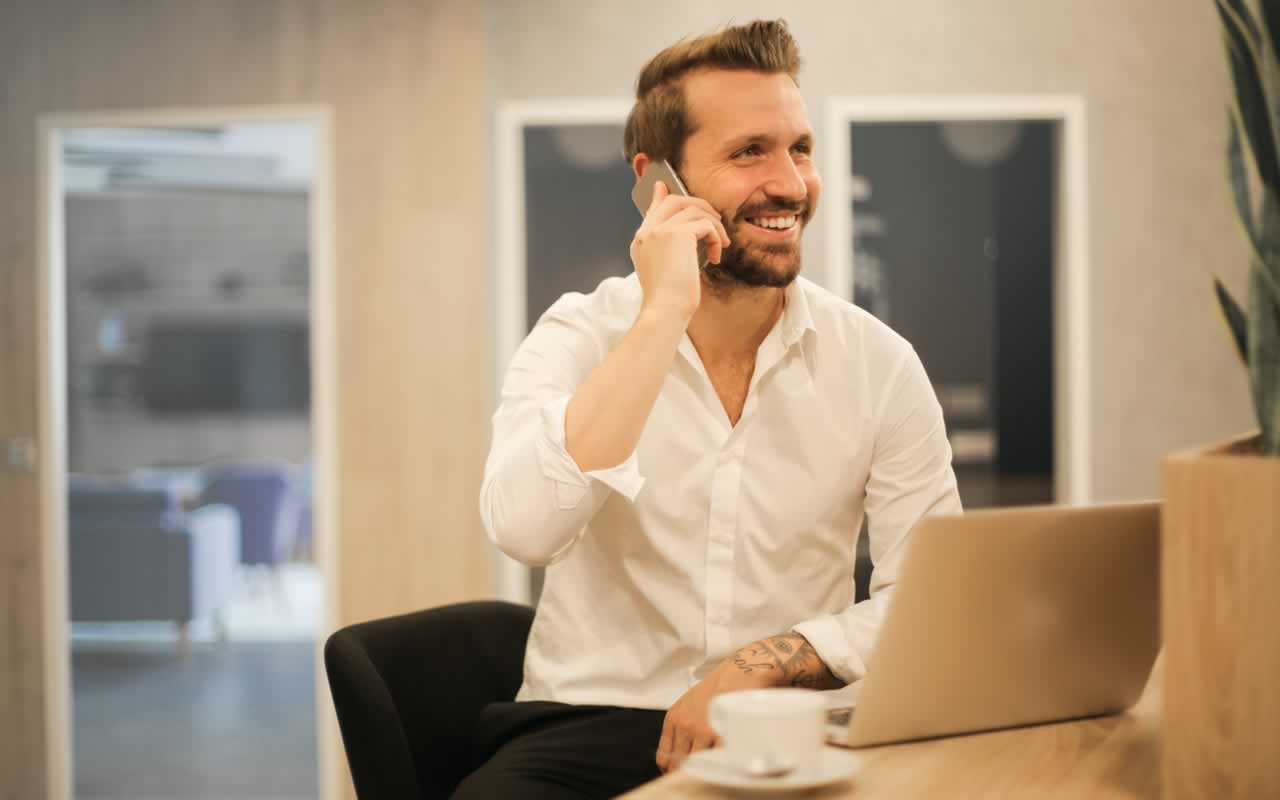 Ein Unternehmer im freundlichen Telefongespräch mit einem Kunden